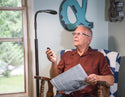 Old man reading newspaper with Stella Floor Lamp